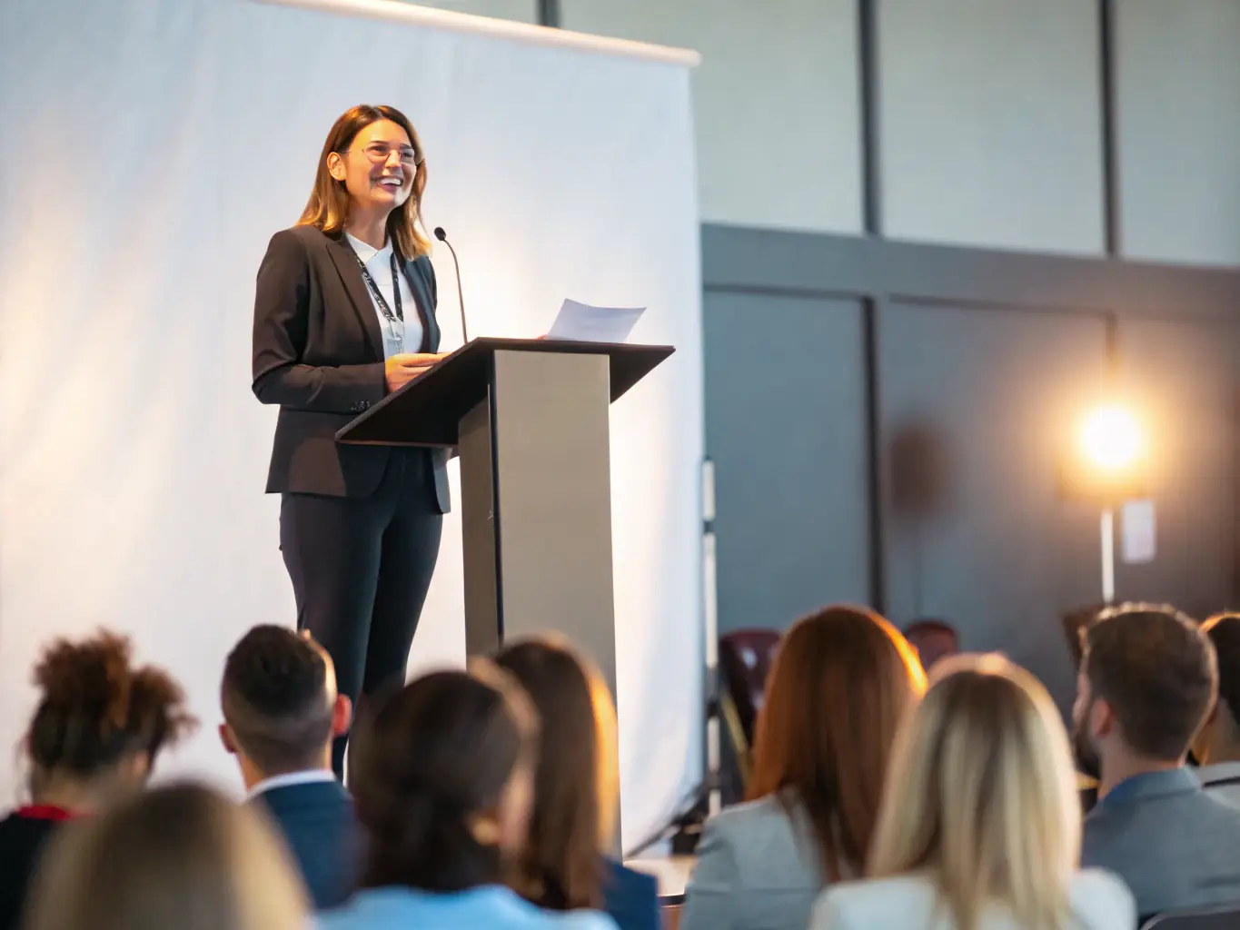 A powerful image of a woman giving a motivational speech at a conference in Fatima, showcasing the empowerment and leadership of women in the region.